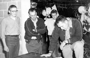 Head coach Keith Gilbertson checks out the list of Panther football prospects while issuing gear in the early 1950s, as assistant coach Dick Rodland looks on. (Gilbertson family photo)