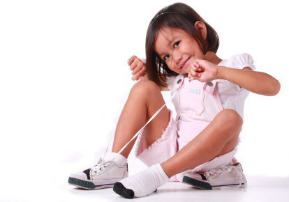 little girl making a tie on her shoe
